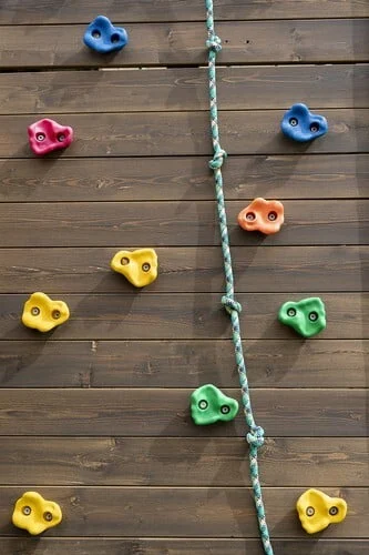 Kids Climbing On Wooden Wall Outdoor.